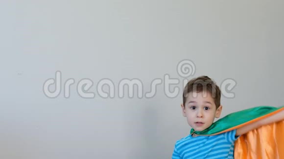 一个坚强自信的男孩穿着超级英雄服装在床上跳跃的肖像成功的概念快乐的童年4k视频视频的预览图