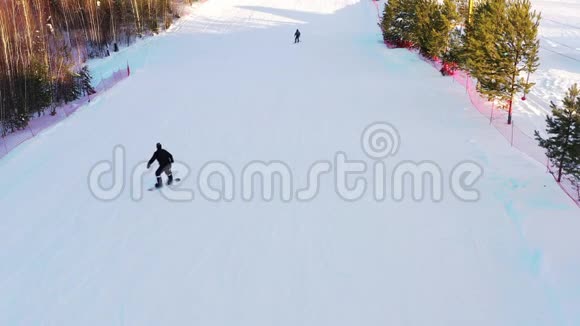 冬季阳光明媚的一天滑雪者从山顶滑下的俯视图滑雪板的概念视频的预览图