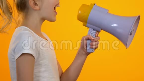 女孩子用扩音器喊叫缓解橙色背景下的压力视频的预览图