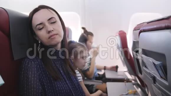 一家人乘飞机去旅行一个女人睡在前面的座位上视频的预览图