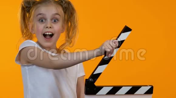 有趣的小孩用拍板和相机微笑初中表演学校视频的预览图