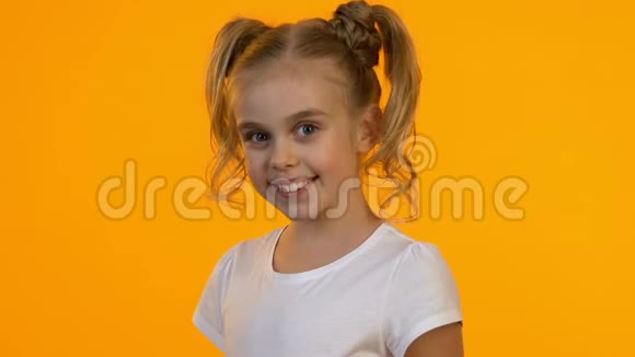 可爱的小女孩在相机上展示红色购物袋微笑着销售视频的预览图