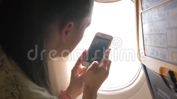 女性在飞机上用智能手机拍照假日旅行和旅行概念视频的预览图