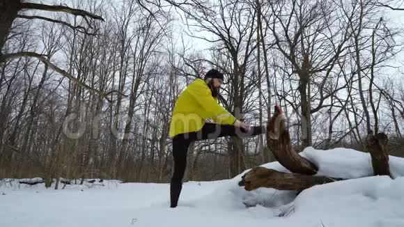 运动苗条的男人在冬林跑步前伸展双腿视频的预览图