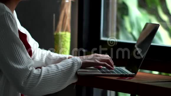 在咖啡店里用手在笔记本电脑上打字视频的预览图