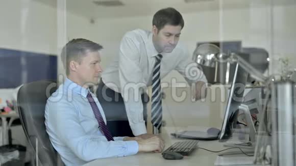 成熟的商业人士在使用办公电脑时与两位嘉宾一同庆祝视频的预览图