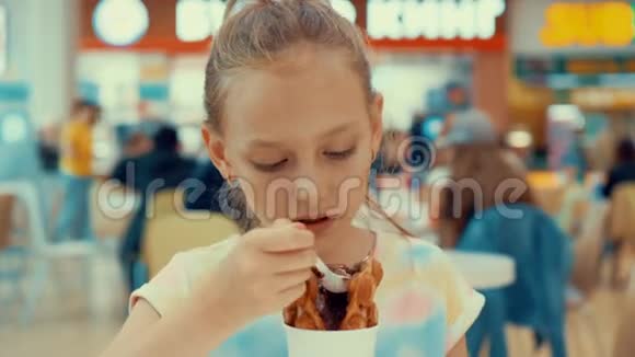 伤心的少年女孩在咖啡馆里吃巧克力冰淇淋十几岁的少女在吃冰淇淋甜点和华夫饼视频的预览图