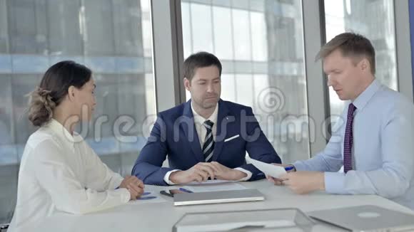 中年商人在会议室与助手会面时阅读文件视频的预览图