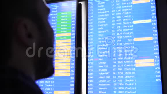 乘客看着时间表屏幕板用手指指着寻找正确的航班视频的预览图