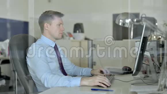 年轻英俊的商人在办公室电脑上做视频聊天视频的预览图
