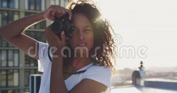 城市屋顶上时尚的年轻女子拍照视频的预览图