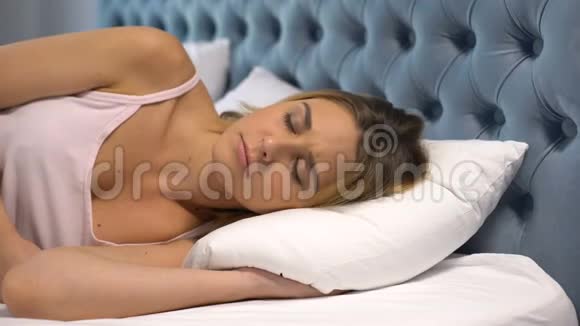患颈痛的年轻女子躺在不舒服的枕头上硬床垫视频的预览图