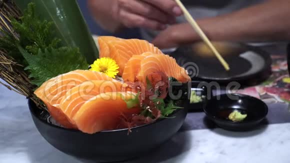 吃生三文鱼刺身日本美丽的装饰盘蘸淑玉和芥末视频的预览图