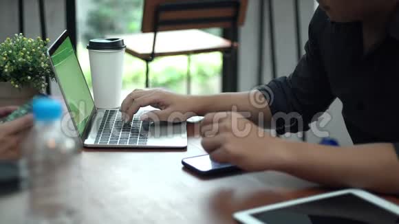 年轻人在咖啡店里打手提电脑视频的预览图