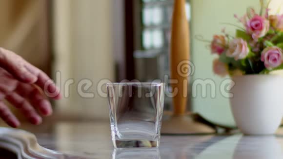 一个人从一个透明的水壶里倒水到水玻璃里视频的预览图