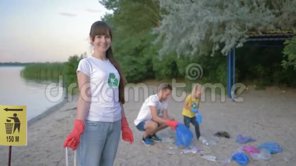 反对污染协会戴着橡胶手套的快乐志愿者女孩的肖像旁边有一个垃圾袋上面有一个标志视频的预览图