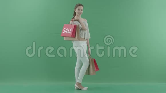 幸福的女人拿着袋子站在绿色的屏幕上视频的预览图