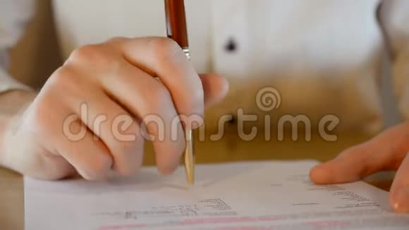在签订一份重要合同之前商人的手在桌上敲着一支金笔视频的预览图