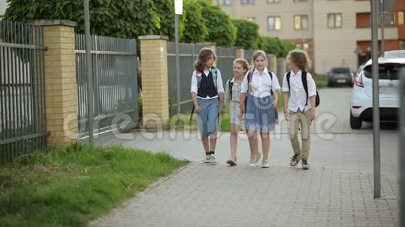 孩子们带着背包在夕阳下从学校回家孩子们回到学校视频的预览图