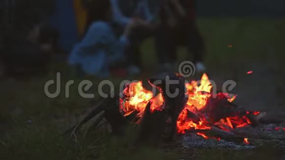 晚上篝火露营的人背景在草地野炊在黑暗中篝火橙色和黄色的火能视频的预览图