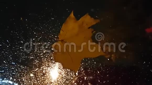 悲伤忧郁的框架汽车挡风玻璃上掉落的枫叶和雨后的水滴秋天天气恶劣视频的预览图