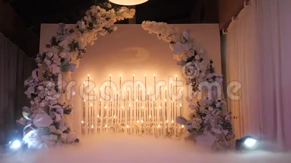 照亮婚礼花拱前的婚礼夜礼餐厅大厅的花卉装饰大气视频的预览图