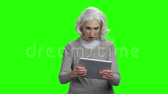 老年妇女在电脑平板电脑上玩游戏视频的预览图