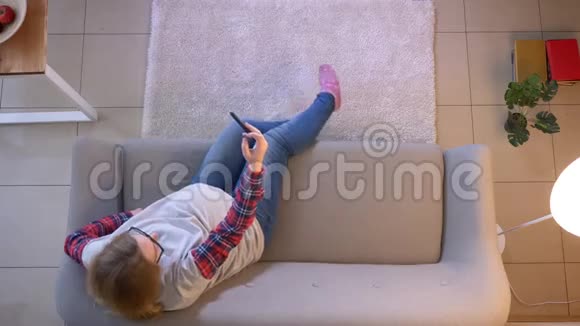 年轻孕妇坐在室内沙发上用手机自拍的特写镜头视频的预览图