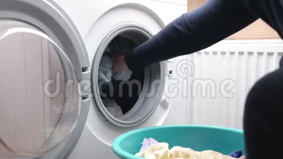 家庭主妇把衣服从洗衣篮装入洗衣机视频的预览图