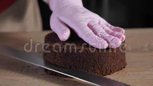 糕点厨师正在用大刀切巧克力海绵蛋糕视频的预览图