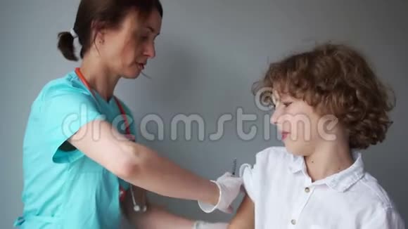 医生给一个卷发男生注射流感疫苗男孩和女人开心地笑着流感疫苗视频的预览图