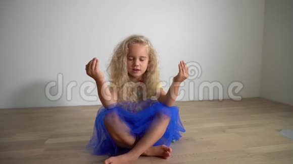 年轻可爱的金发女孩坐在地板上做瑜伽万向节运动视频的预览图