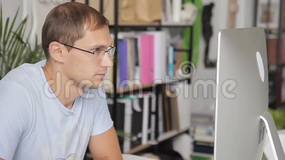 戴眼镜的人仔细地看着办公室里的监控屏幕视频的预览图