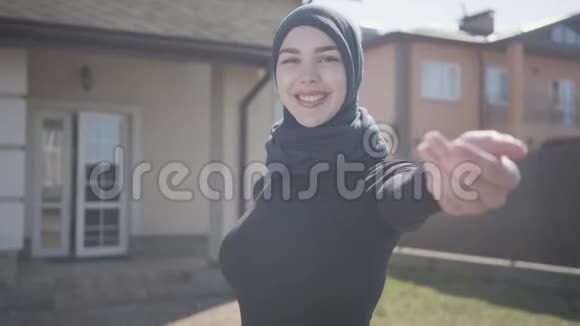 独立的年轻穆斯林妇女戴着传统头巾微笑调情的肖像带接线员的可爱女孩视频的预览图