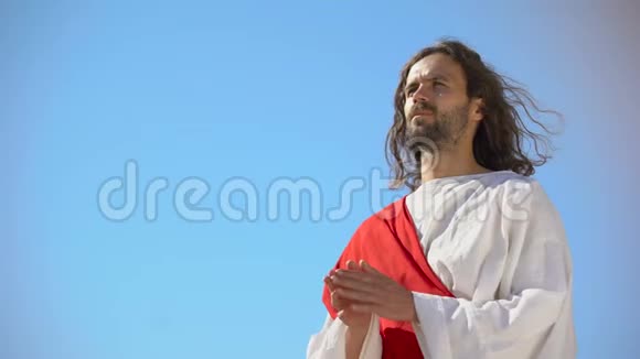 穿长袍的人在蓝天的背景下向上帝祈祷请求灵魂的救赎视频的预览图