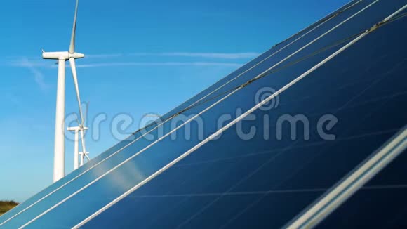 靠近一个大型太阳能电池板后面有风力涡轮机视频的预览图