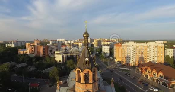 俄罗斯日落时分城市街道上有房子和教堂的空中拍摄视频的预览图