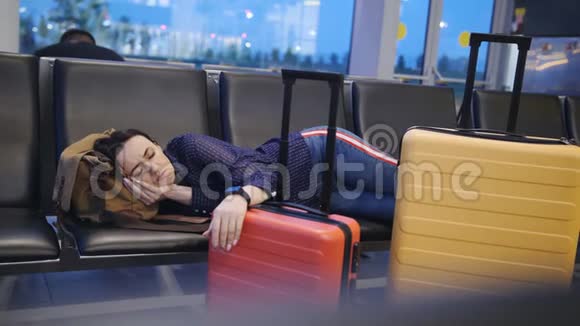 美丽迷人的女人睡在机场航站楼长途连接飞行时差女人睡在视频的预览图