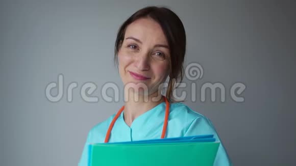 一个穿着医疗服的医生女人的肖像手里拿着一个音筒和一个文件夹心理医生看着视频的预览图