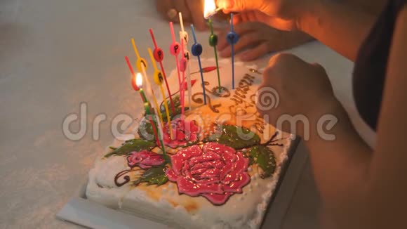 妈妈在生日蛋糕上点燃蜡烛让孩子们在家里庆祝视频的预览图