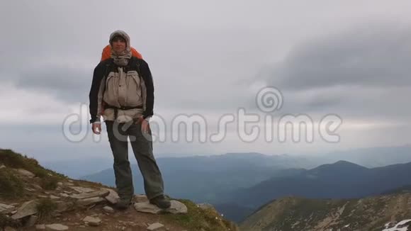勇敢的游客背着背包手挽着懒腰的山顶视频的预览图