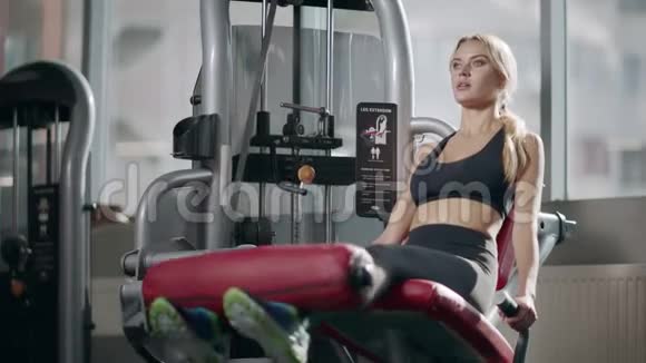 运动女性在健身馆健身机上做腿部运动视频的预览图