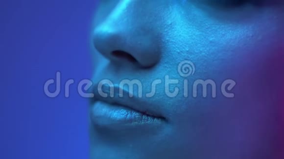 特写镜头的未来时尚模特的嘴唇在彩色霓虹灯在工作室视频的预览图