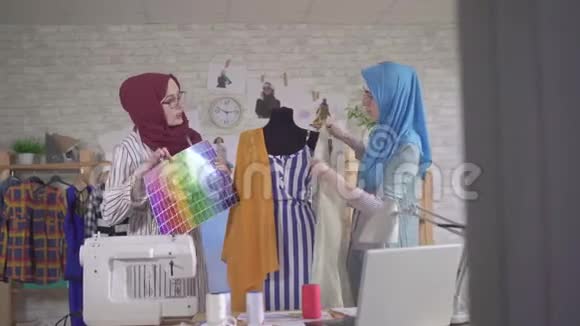 年轻的穆斯林女性时装设计师在国家头巾在现代工作室视频的预览图