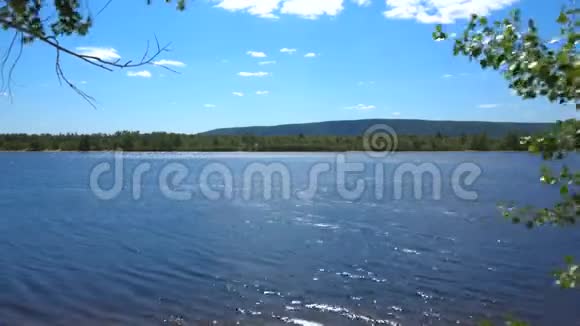 这条河在刮风的天气里河和山的景色视频的预览图
