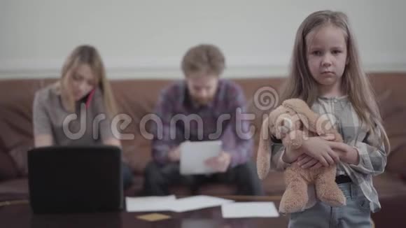 年轻女子在她的笔记本电脑上打字用手机说话胡子男在后台工作他的平板电脑小可爱视频的预览图