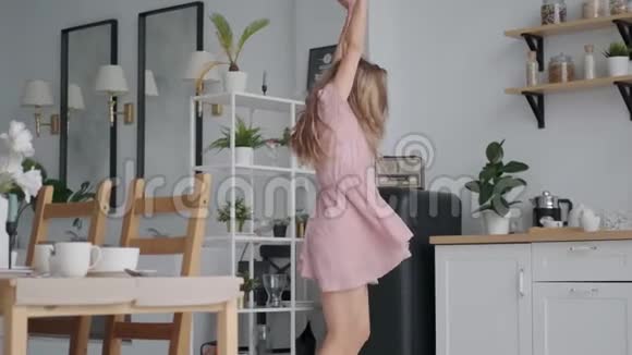 有趣的女孩疯狂地在厨房跳舞和跳跃视频的预览图