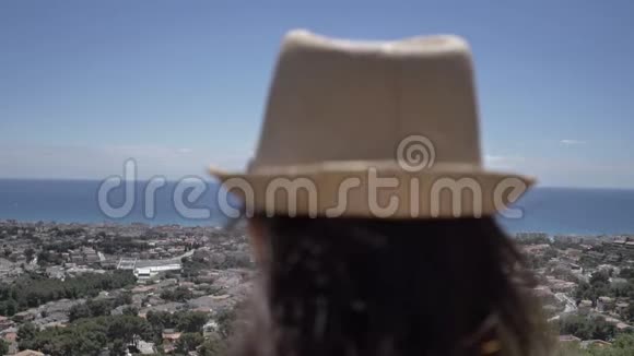 戴帽子的女人俯视城市和大海仰视风景旅行理念视频的预览图