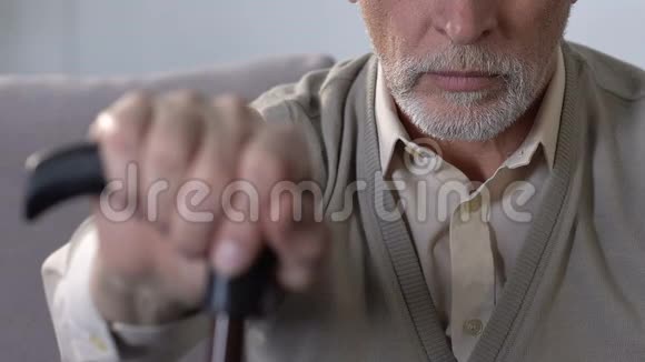 老人手拿拐杖走路残疾和关节问题健康视频的预览图