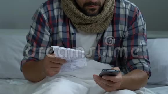 病男在智能手机上在线订购药丸搜索信息坐在床上视频的预览图
